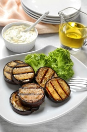 Plate with fried eggplant slices on table