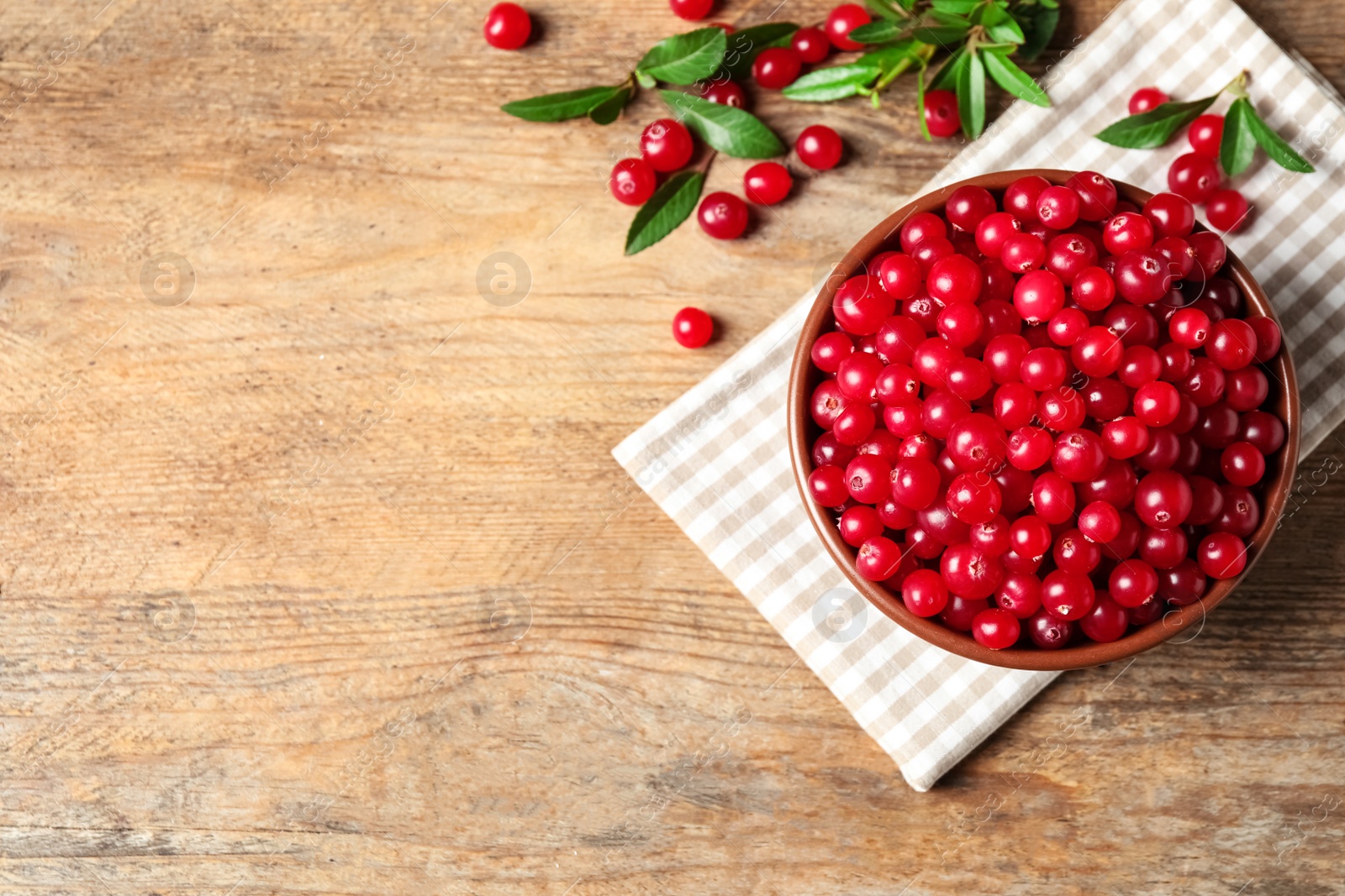 Photo of Tasty ripe cranberries on wooden table, flat lay. Space for text