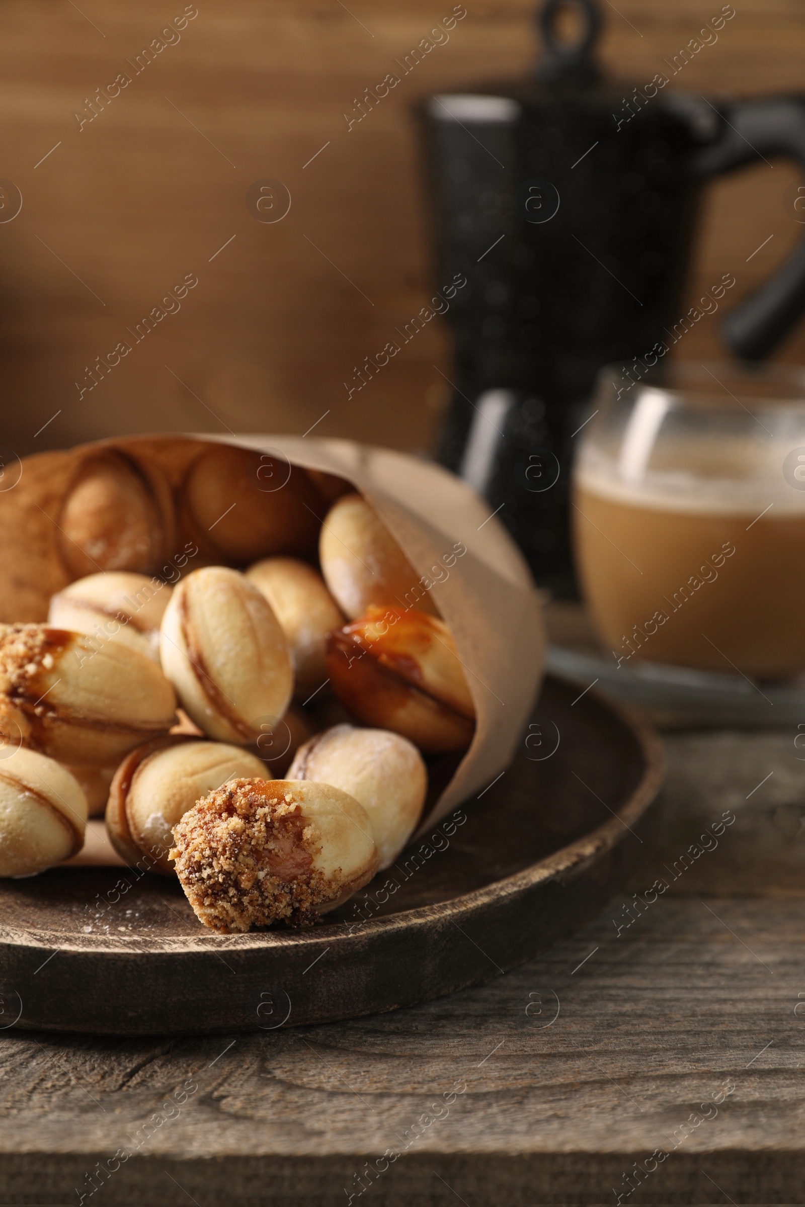 Photo of Freshly baked homemade walnut shaped cookies on wooden table, closeup