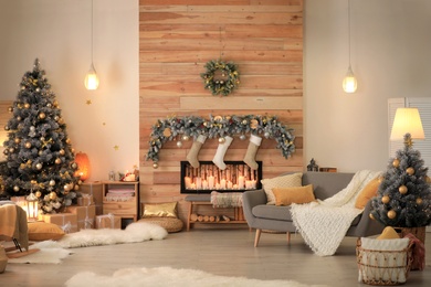 Photo of Stylish room interior with beautiful Christmas tree and decorative fireplace