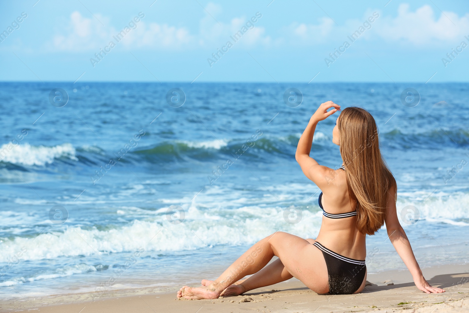 Photo of Attractive young woman in beautiful bikini swimsuit on beach