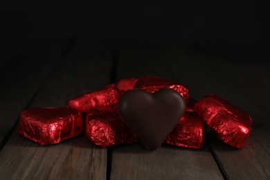 Photo of Beautiful heart shaped chocolate candies on wooden table