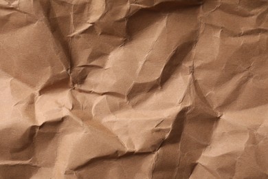 Photo of Crumpled kraft paper sheet as background, top view