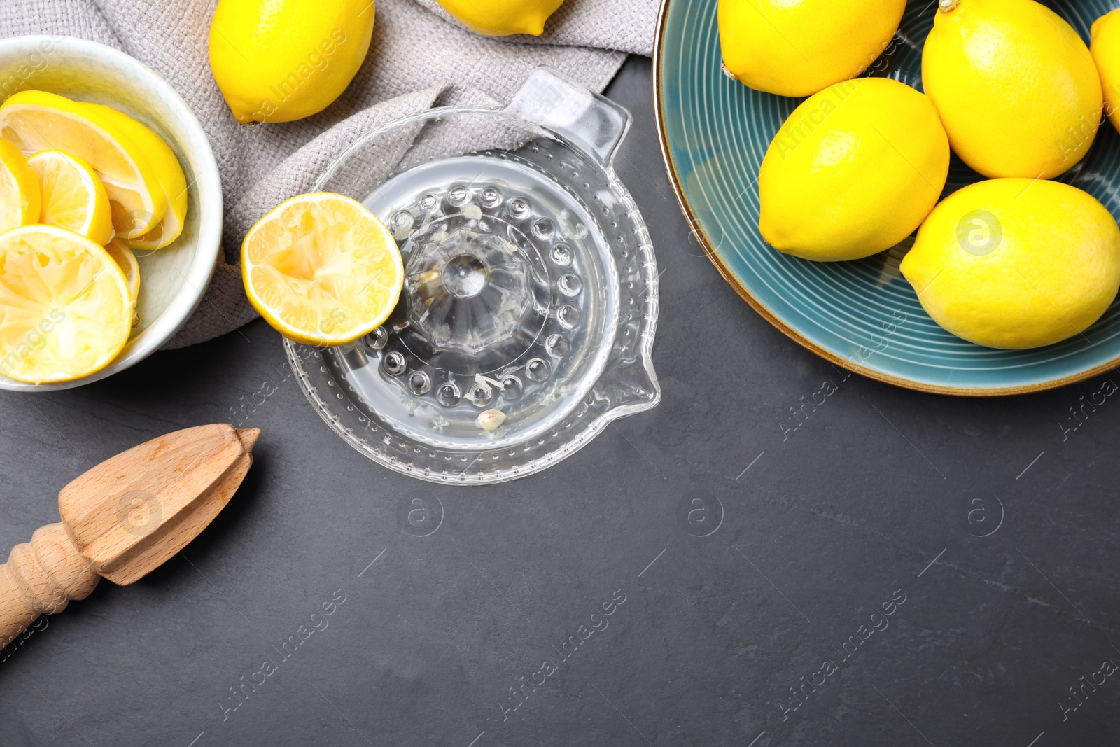 Photo of Flat lay composition with freshly squeezed lemon juice on dark table