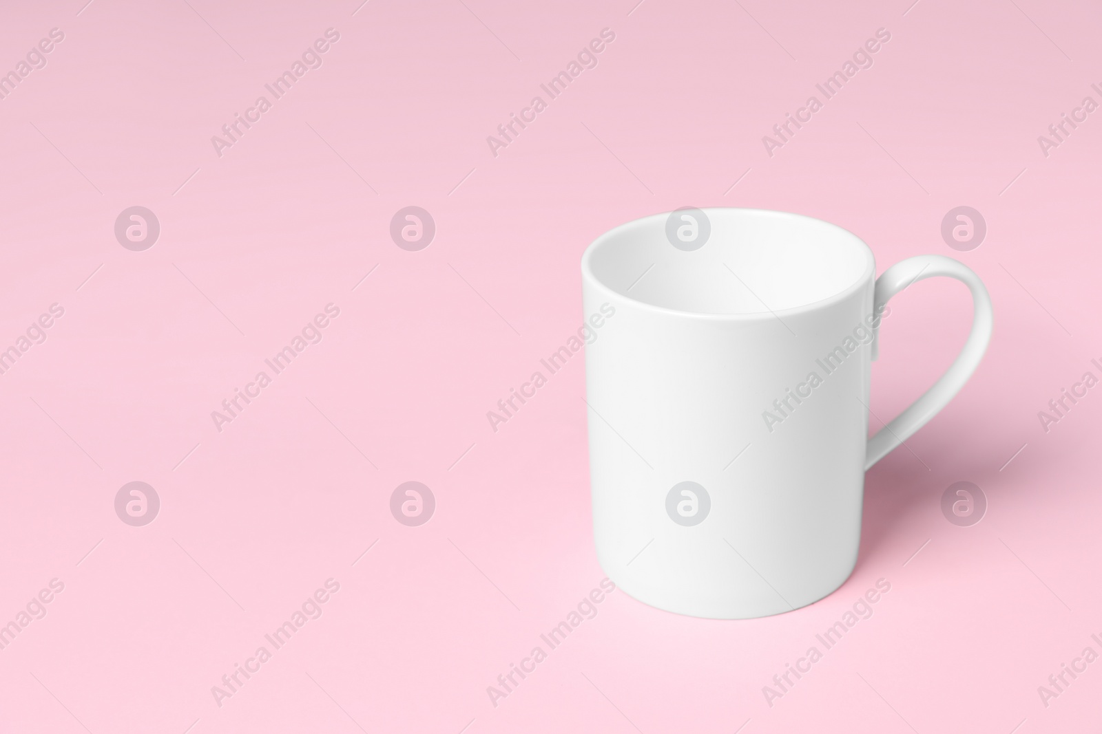 One white ceramic mug on pink background, space for text Photo of One white ceramic mug on pink background, space for text