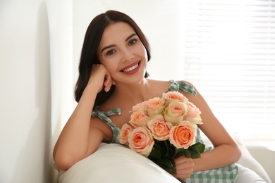 Photo of Young woman with beautiful bouquet at home