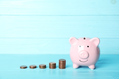 Piggy bank and different height coin stacks against color background. Space for text