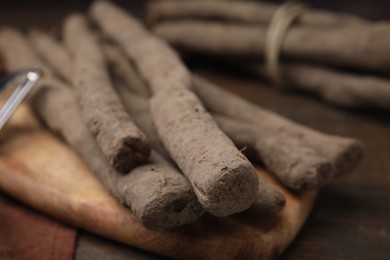 Photo of Fresh raw salsify roots on table, closeup view