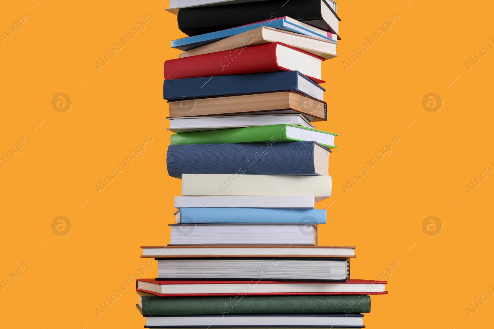 Photo of Stack of hardcover books on orange background