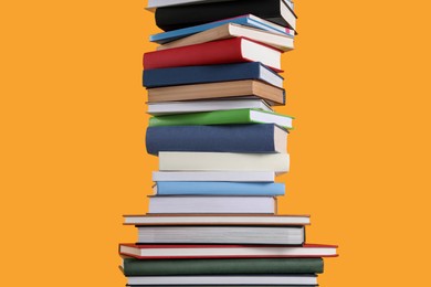 Stack of hardcover books on orange background