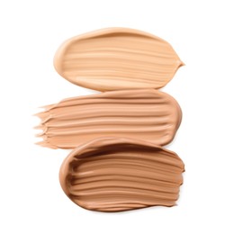 Samples of liquid skin foundations on white background, top view