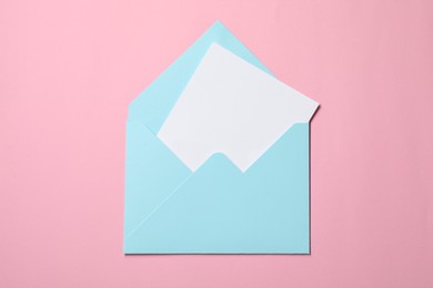 Photo of Letter envelope with card on pink background, top view