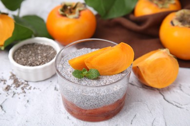 Photo of Delicious dessert with persimmon and chia seeds on table