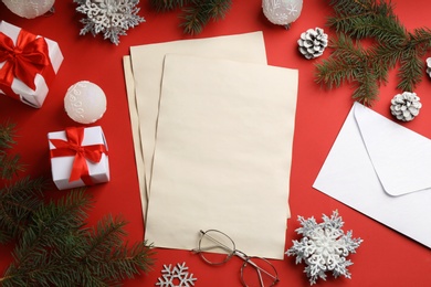 Photo of Flat lay composition with blank sheets of paper on red background, space for text. Writing letter to Santa