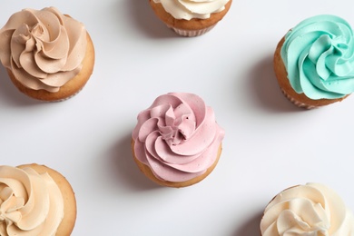 Flat lay composition with delicious birthday cupcakes on white background