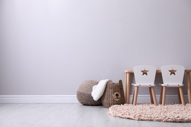 Photo of Cute child room interior with furniture near light grey wall, space for text