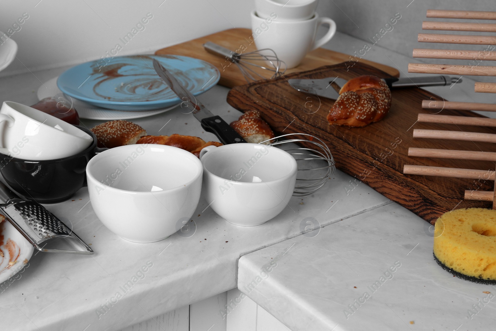 Photo of Many dirty utensils, dishware and food leftovers on countertop in messy kitchen