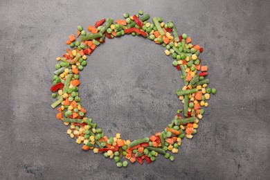 Photo of Frame made of different frozen vegetables on grey table, flat lay. Space for text