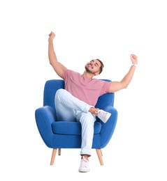 Emotional young man sitting in armchair on white background