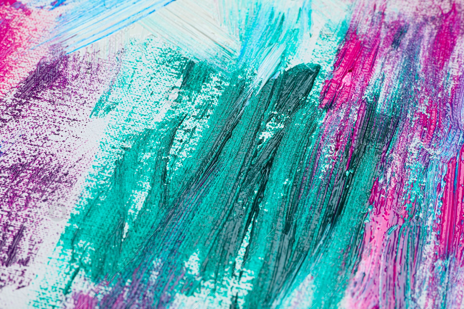 Photo of Strokes of colorful acrylic paints on white canvas, closeup