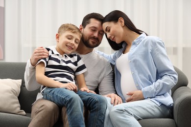 Photo of Pregnant woman spending time with her son and husband at home