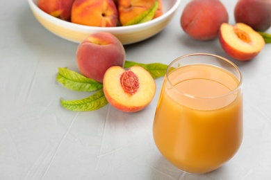 Photo of Natural freshly made peach juice on light table, closeup