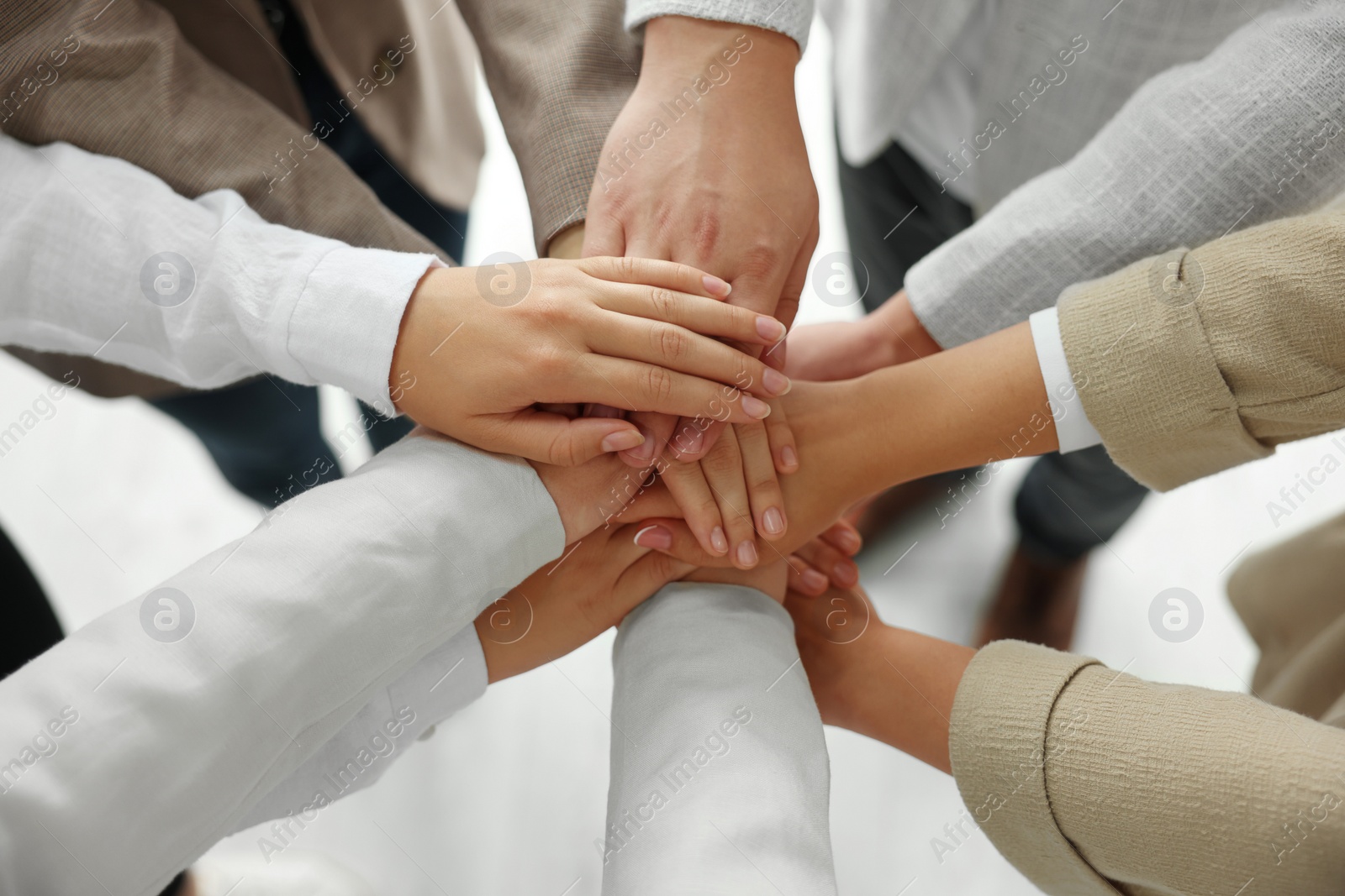 Photo of Group of people holding hands together indoors, above view. Unity concept