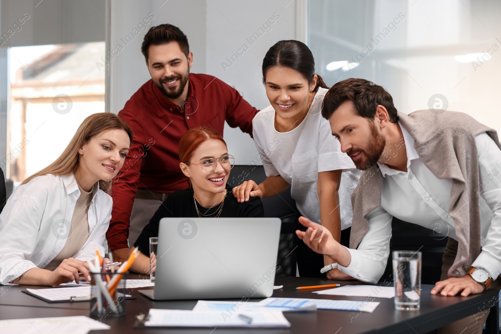 Photo of Team of employees working together in office