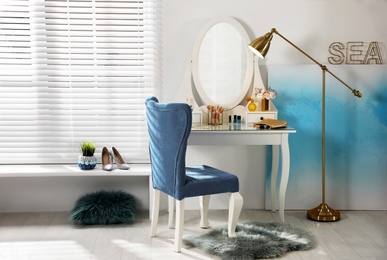 Photo of Elegant dressing table and blue chair in stylish room interior