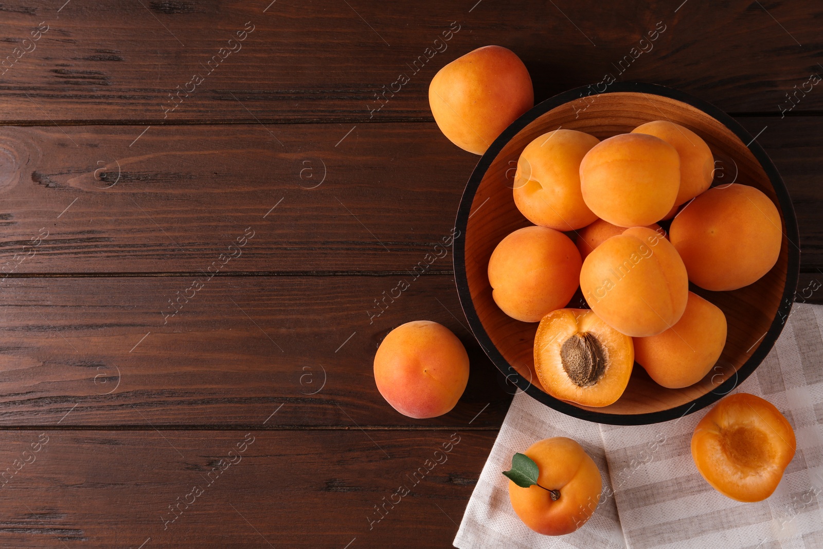 Photo of Composition with delicious apricots on brown wooden background, top view. Space for text