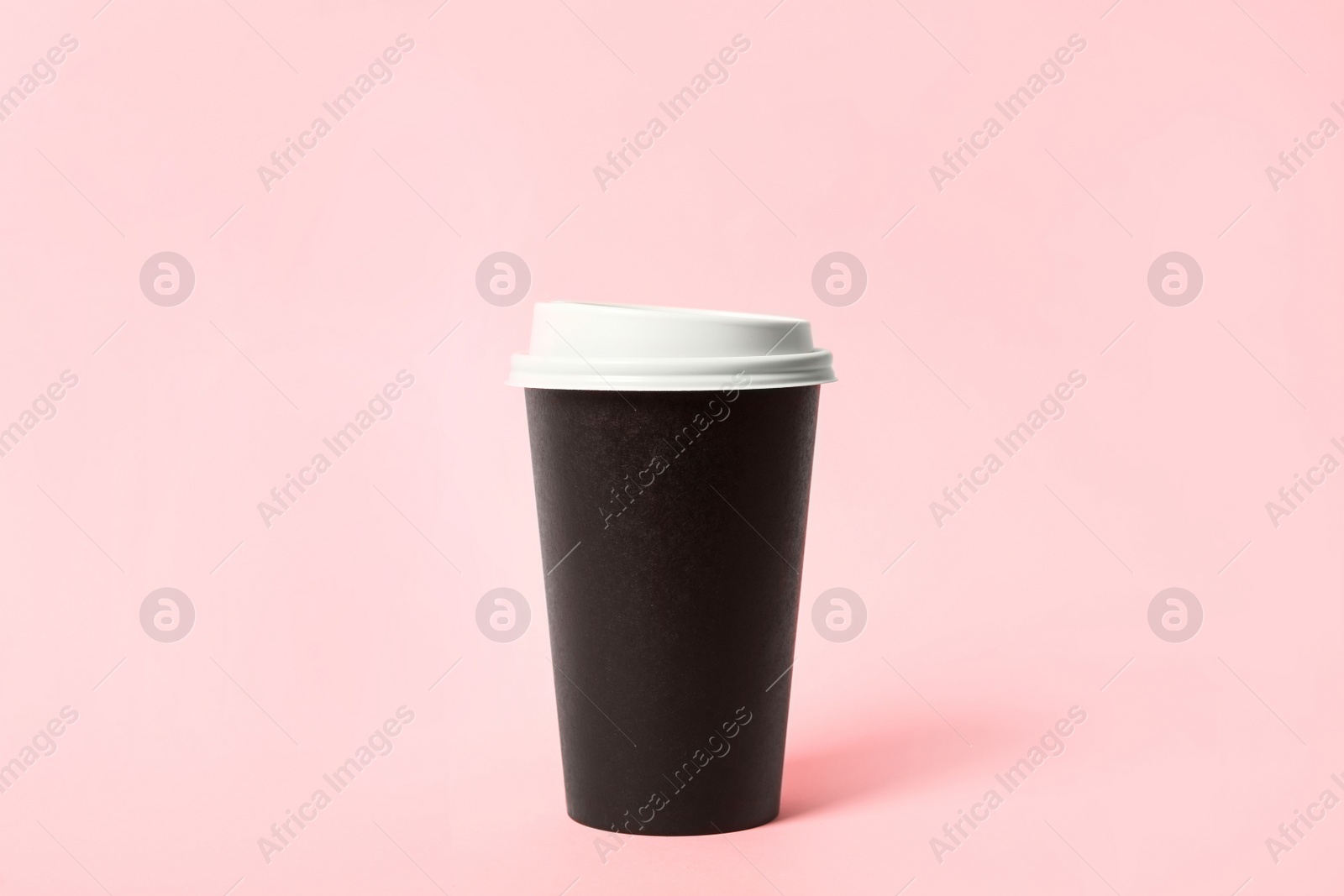 Photo of Takeaway paper coffee cup on pink background