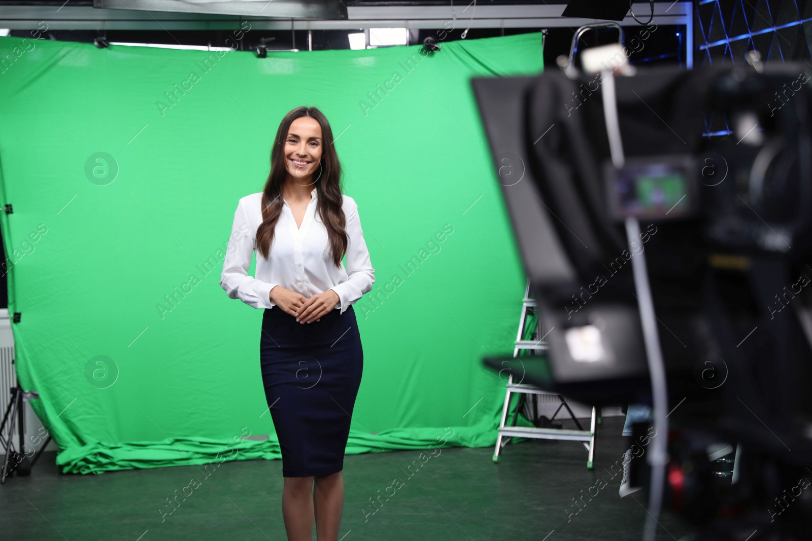 Photo of Presenter and video camera operator working in studio. News broadcasting