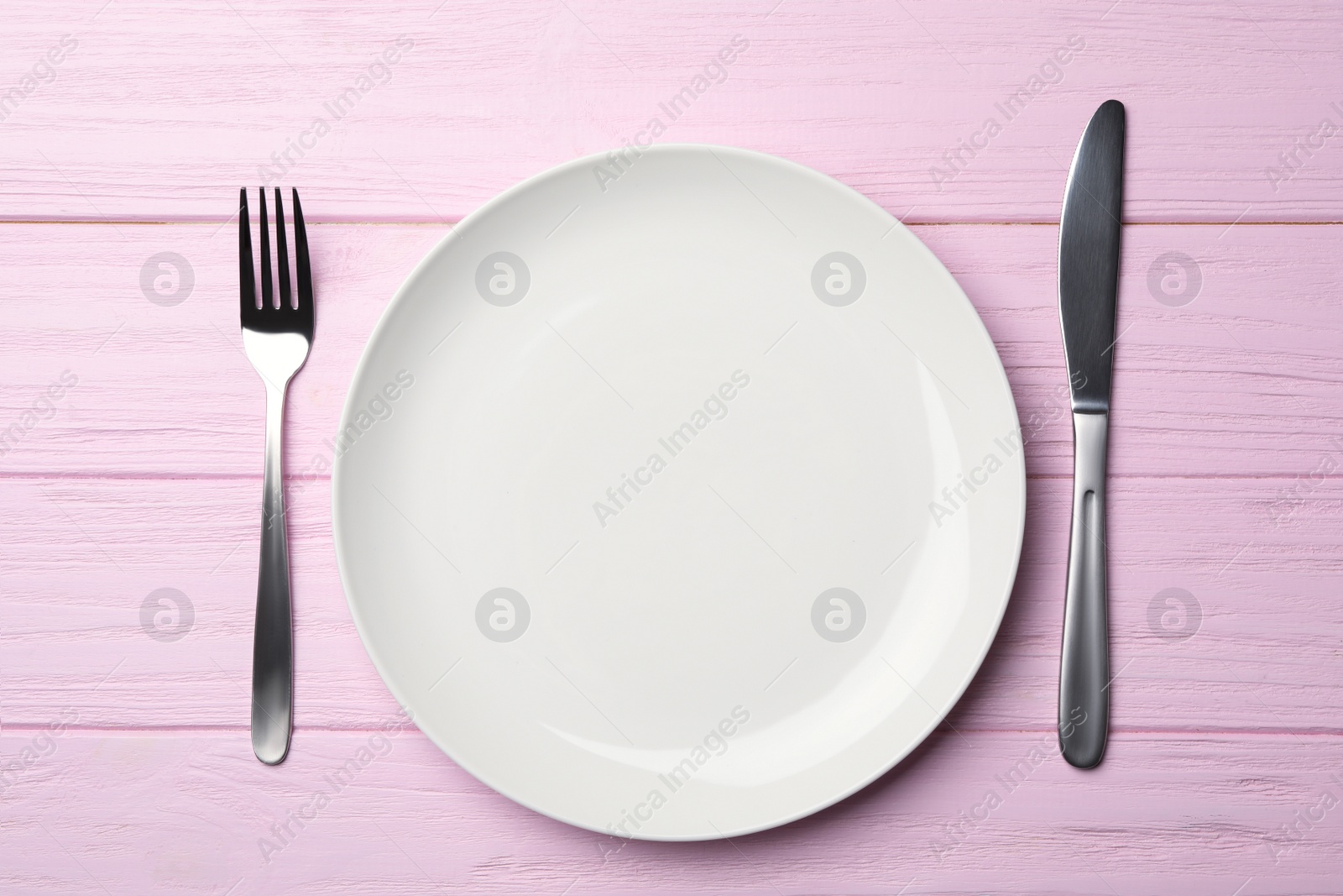 Photo of Stylish ceramic plate and cutlery on wooden background, flat lay