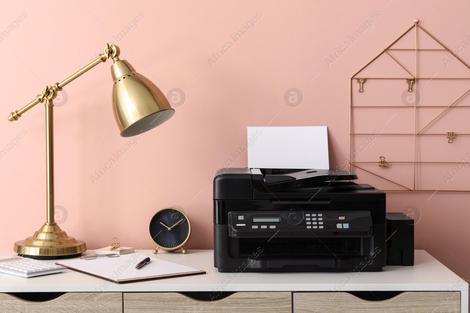 Photo of New modern printer with paper on white table at workplace