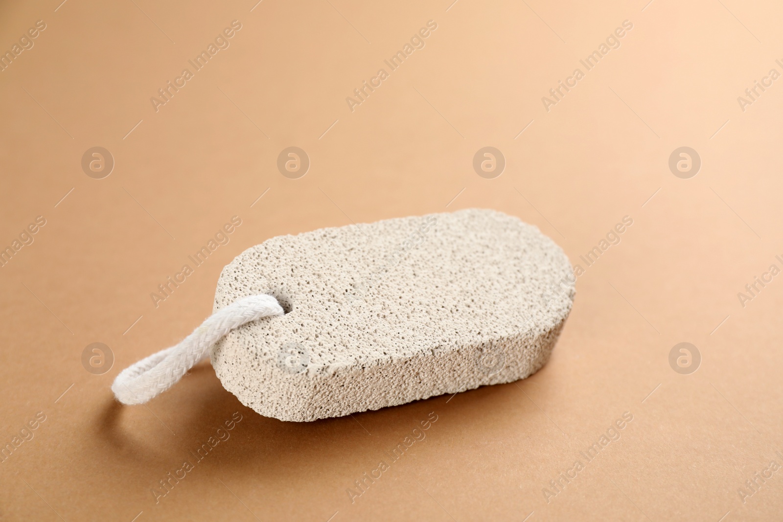 Photo of Pumice stone on brown background. Pedicure tool