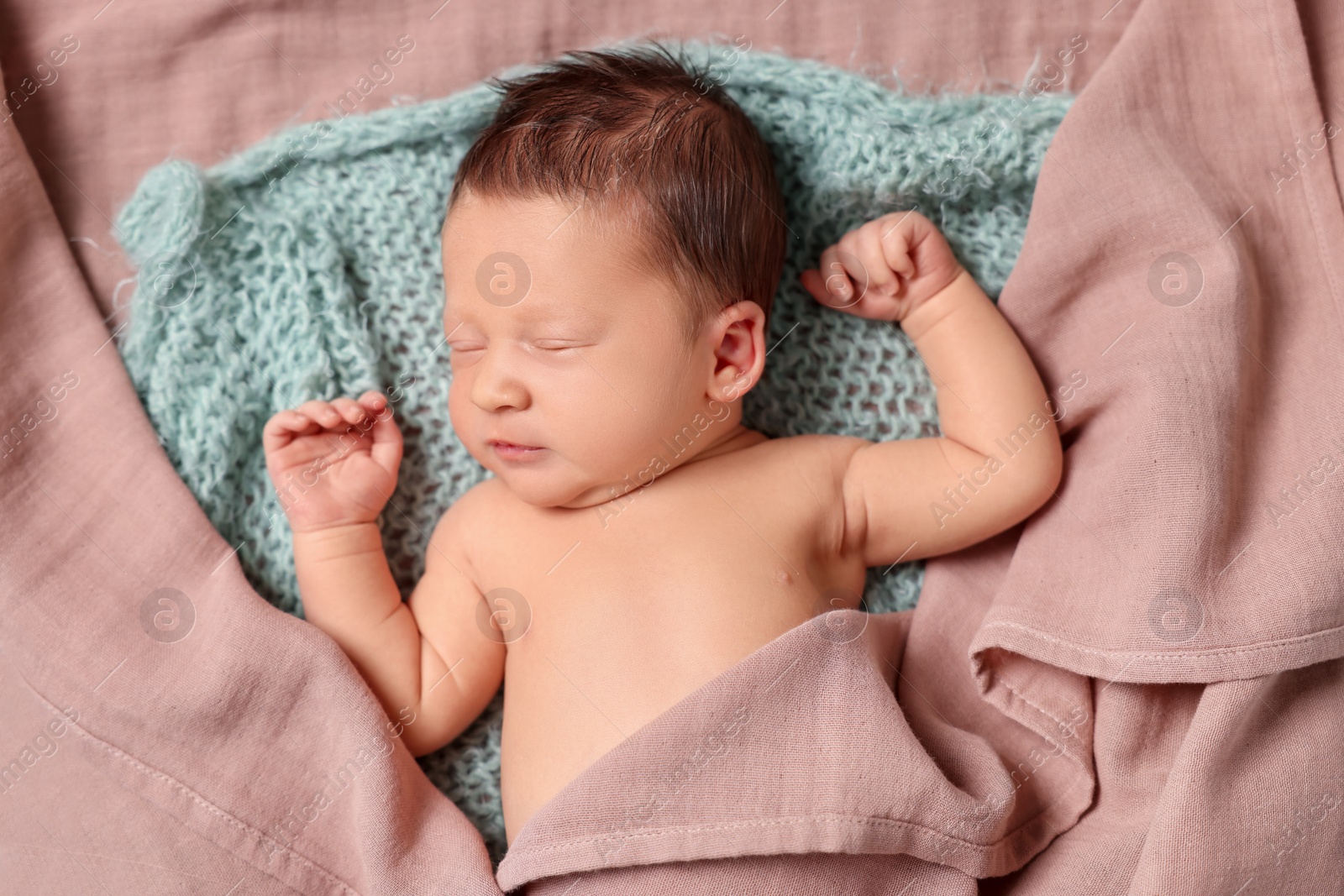 Photo of Cute newborn baby sleeping on knitted blanket, top view