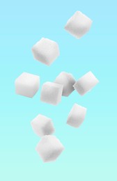 Image of Refined sugar cubes in air on light blue background