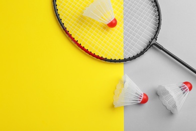 Photo of Badminton racket and shuttlecocks on color background, flat lay. Space for text