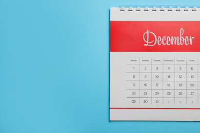 Photo of December calendar on light blue background, top view. Space for text