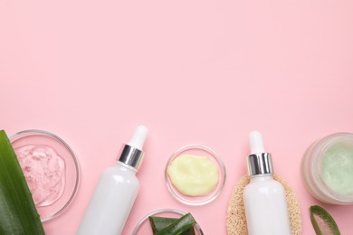 Photo of Flat lay composition with cosmetic products and cut aloe leaves on pink background. Space for text