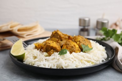 Photo of Delicious chicken curry with rice on grey table, closeup