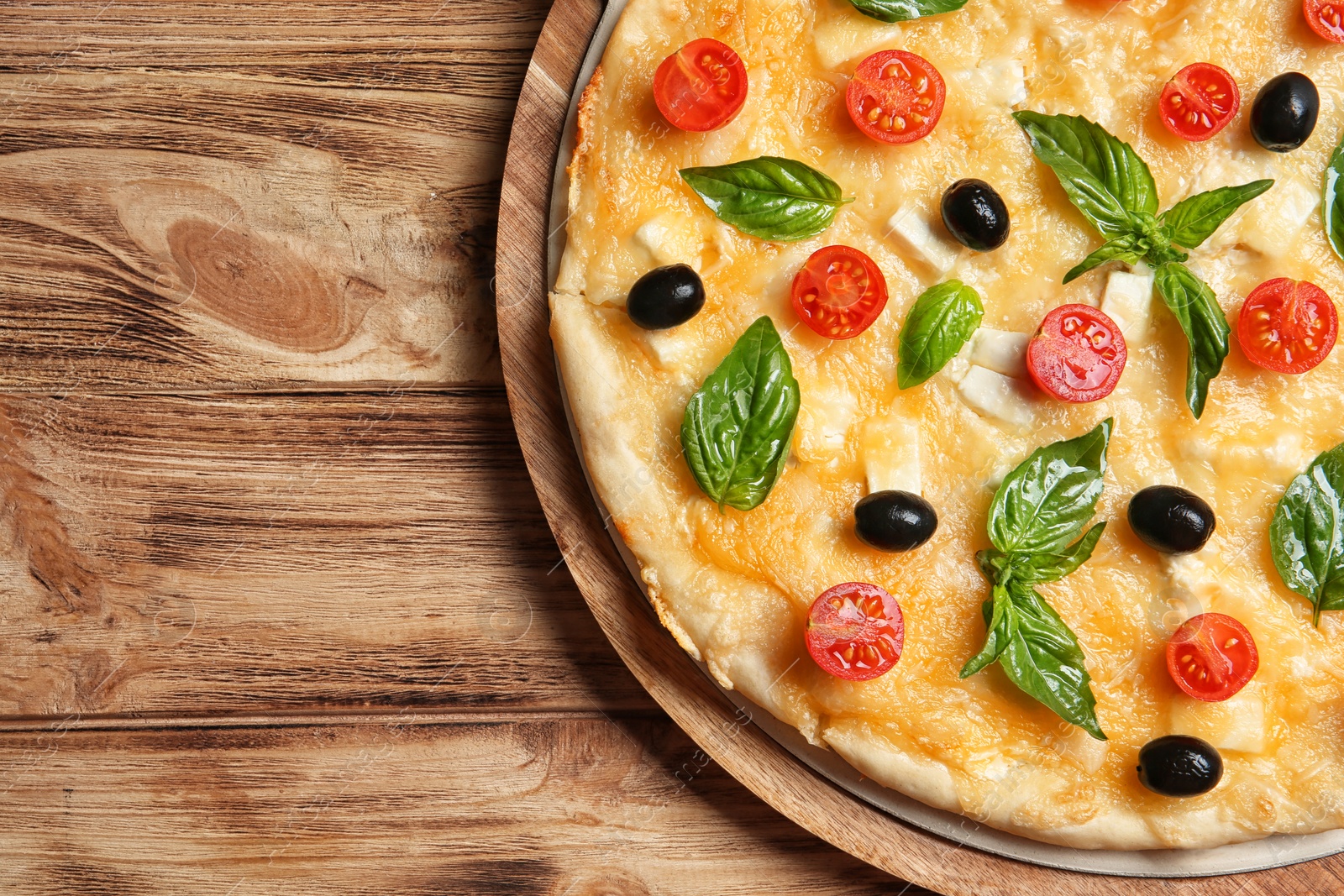 Photo of Fresh tasty homemade pizza and space for text on wooden background, top view