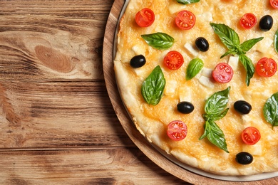 Photo of Fresh tasty homemade pizza and space for text on wooden background, top view