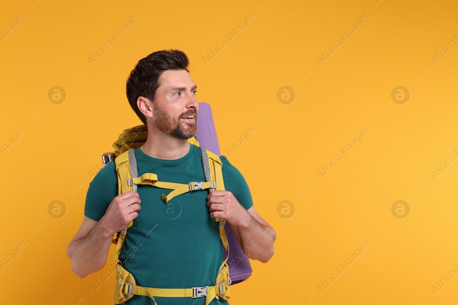 Photo of Man with backpack on orange background, space for text. Active tourism