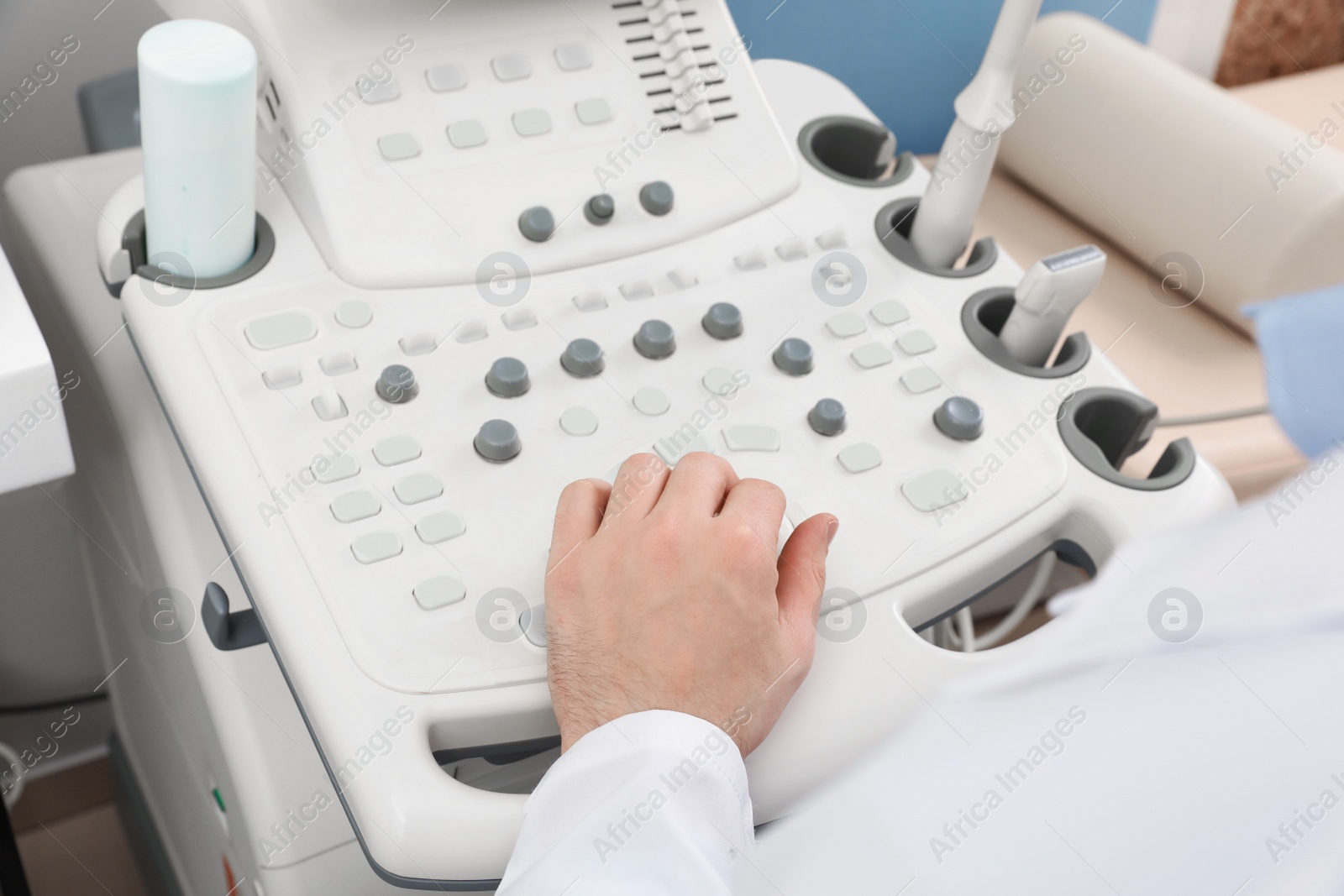 Photo of Sonographer operating modern ultrasound machine in clinic, closeup