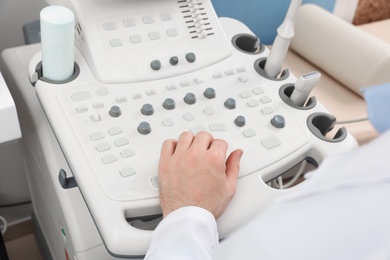 Sonographer operating modern ultrasound machine in clinic, closeup