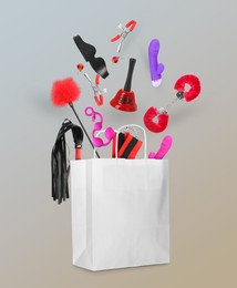 Image of DIfferent sex toys and accessories falling into paper shopping bag on color background