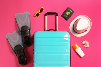 Photo of Flat lay composition with suitcase and traveler's accessories on color background