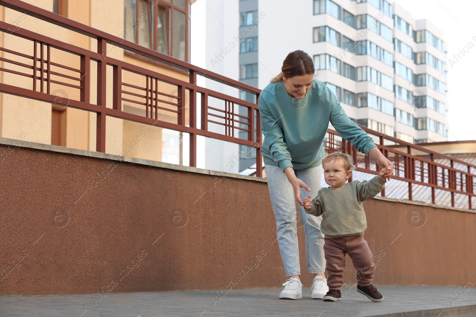 Photo of Happy nanny walking with cute little boy outdoors