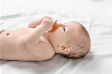 Cute little baby lying on bed at home